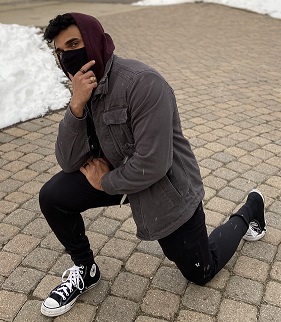 Ashis patel holding his chin while kneeling on the ground